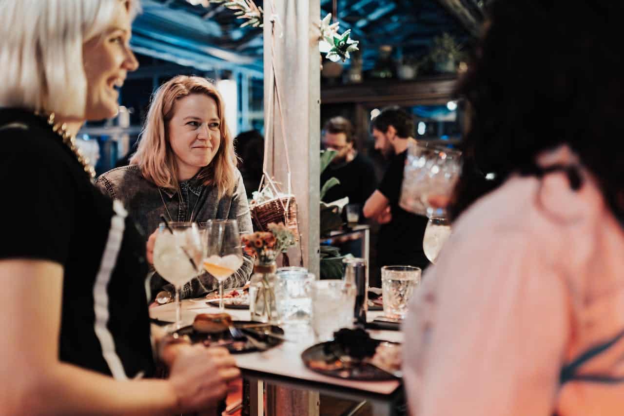 Photo by Matheus Bertelli: https://www.pexels.com/photo/group-of-people-sitting-at-a-table-during-a-party-18999489/ -- women networking