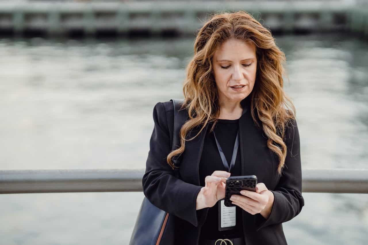 Photo by Mizuno K: https://www.pexels.com/photo/woman-standing-with-a-phone-on-a-bridge-13801691/