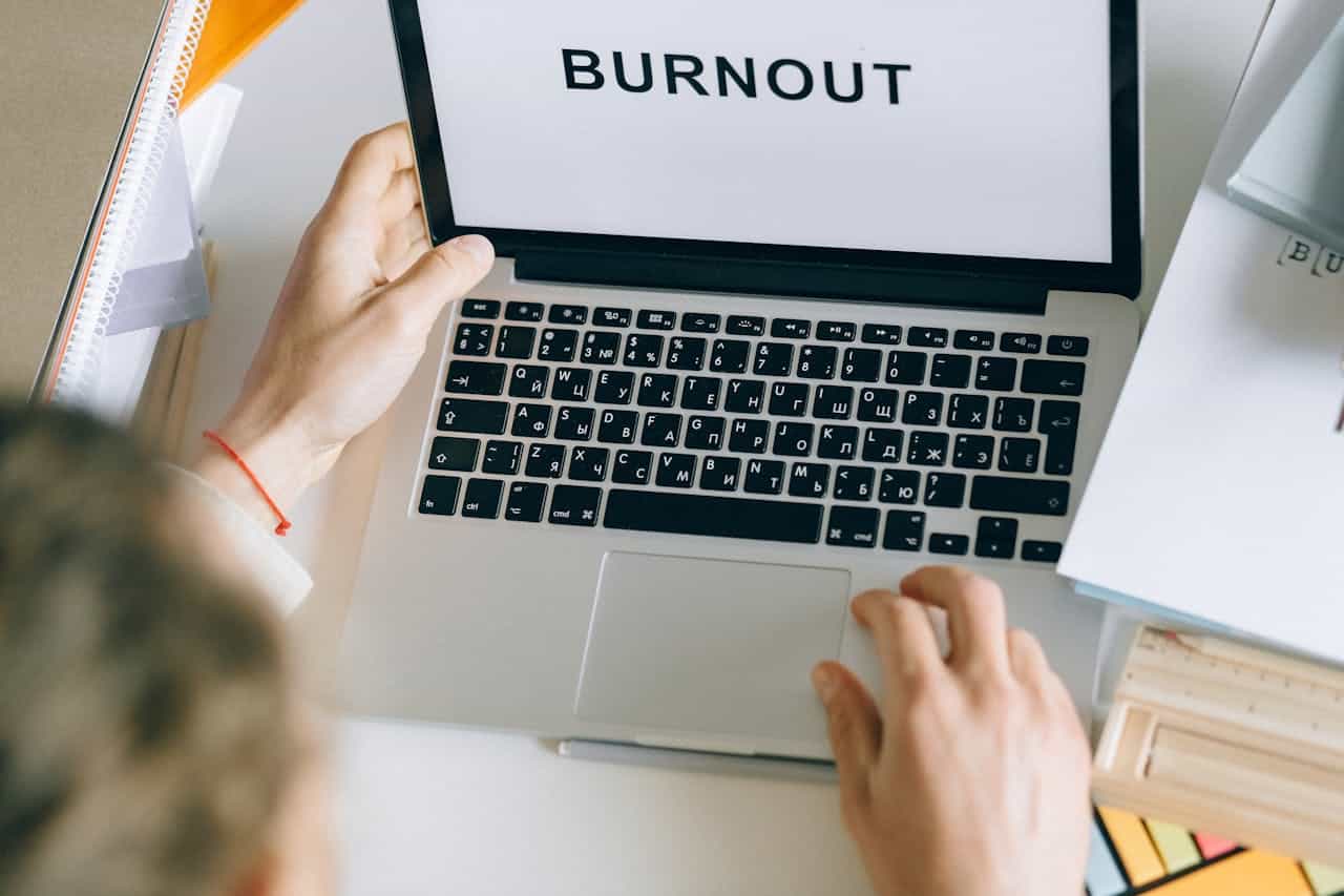 Photo by Nataliya Vaitkevich: https://www.pexels.com/photo/person-using-gray-laptop-6837649/ -- avoid burnout with your event planning business