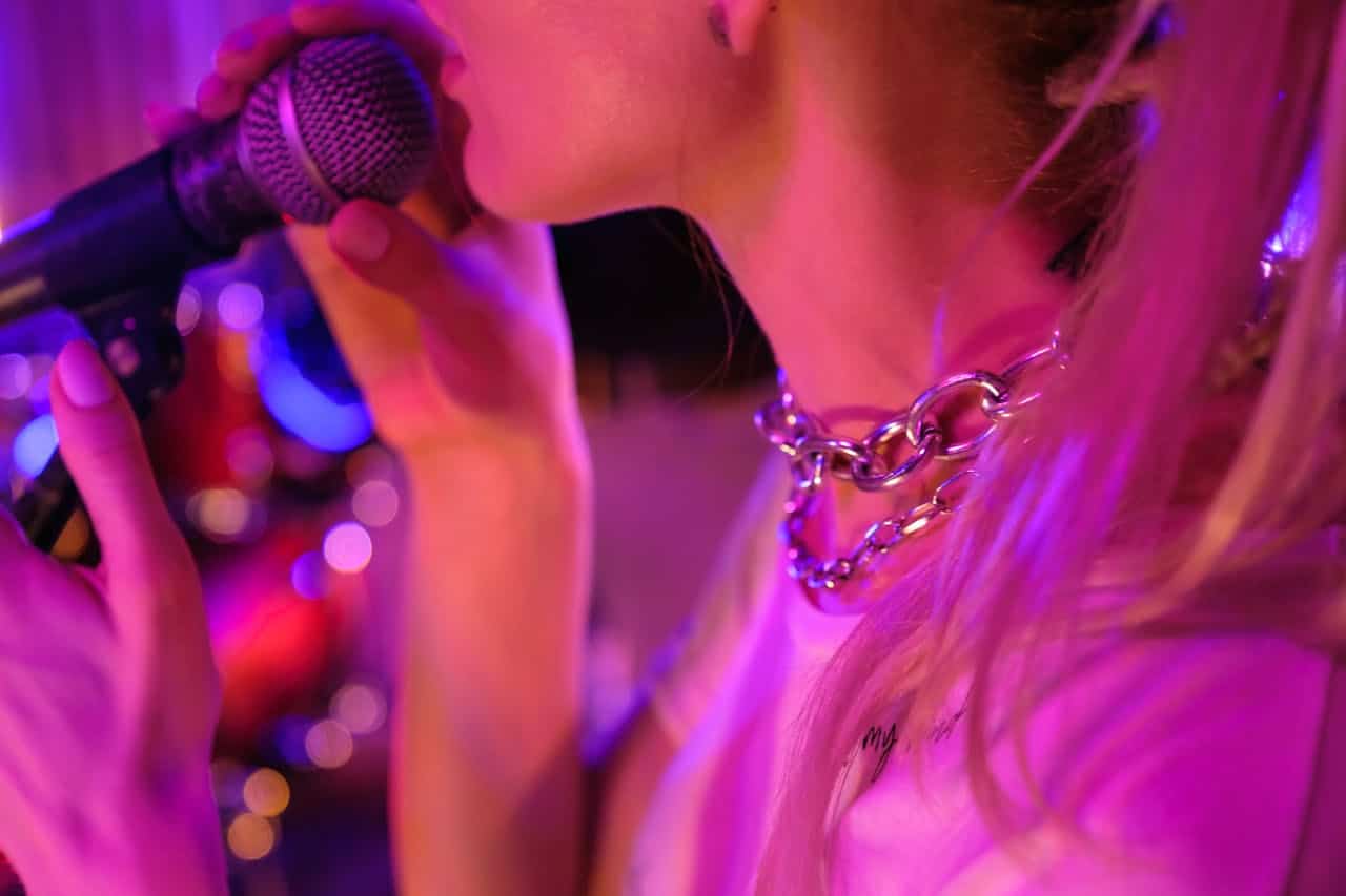 Photo by Big Bag Films: https://www.pexels.com/photo/close-up-shot-of-a-woman-using-microphone-8512698/ -- lip sync