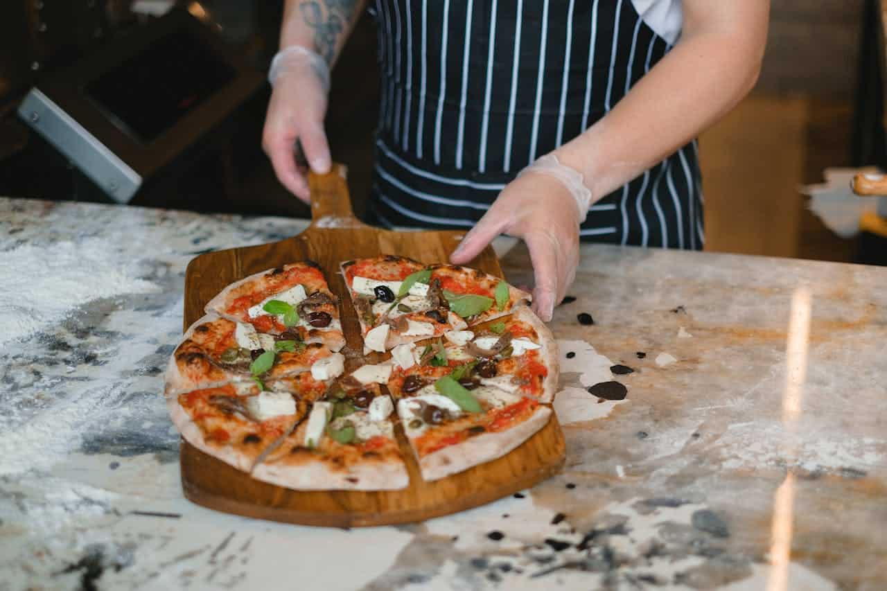 Photo by Anna Shvets: https://www.pexels.com/photo/person-holding-a-pizza-on-a-serving-board-5953518/